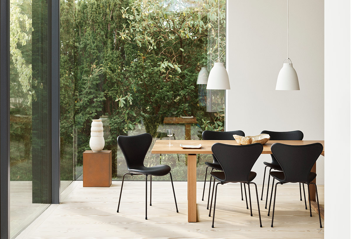 Serie 3107 von Fritz Hansen in Schwarz an einem Esstisch aus Holz